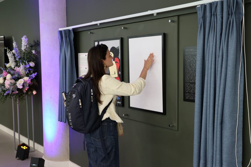 Conference participant with their hand on the canvas to experience the artwork through touch.