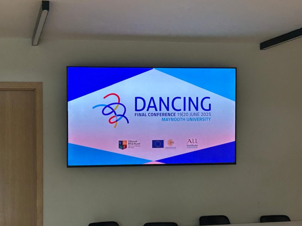 Large screen displaying the digital poster of the conference inside the MU TSI Building.